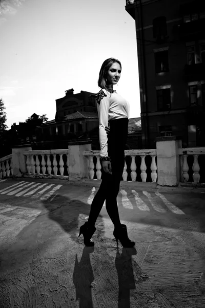 Chica caminando en la calle contra los tejados — Foto de Stock
