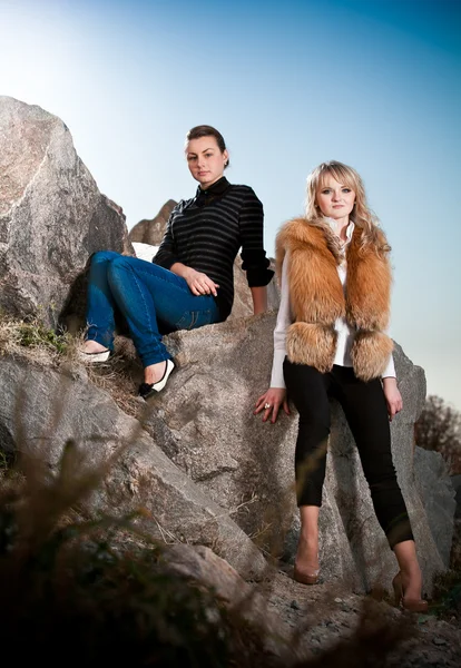 Dos chicas posando sobre rocas — Foto de Stock