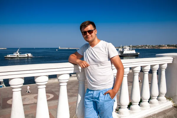 Man in sunglasses standing on embankment — Stock Photo, Image