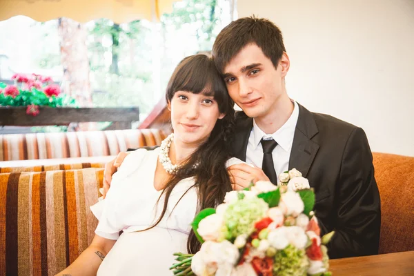 Brudgummen och bruden sitter på terrassen på restaurang — Stockfoto