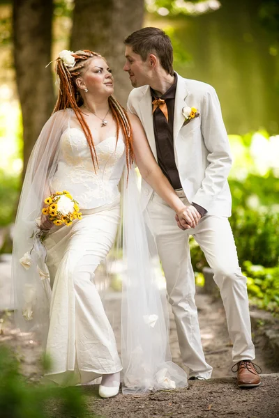 Bride with red dreadlocks looking at handsome groom — Stock Photo, Image