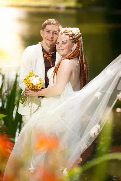 Married couple hugging near bank in reeds — Stock Photo, Image