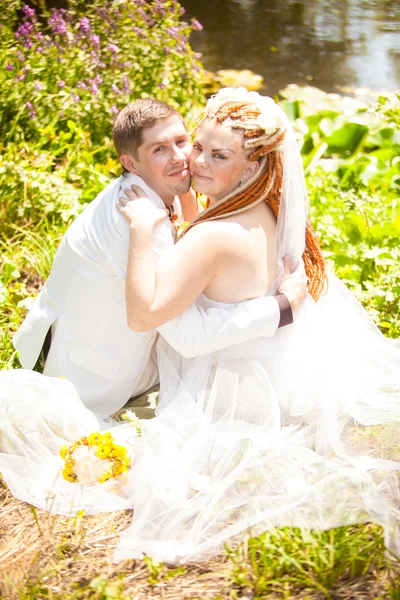 Newly married couple hugging on glade in park — Stock Photo, Image