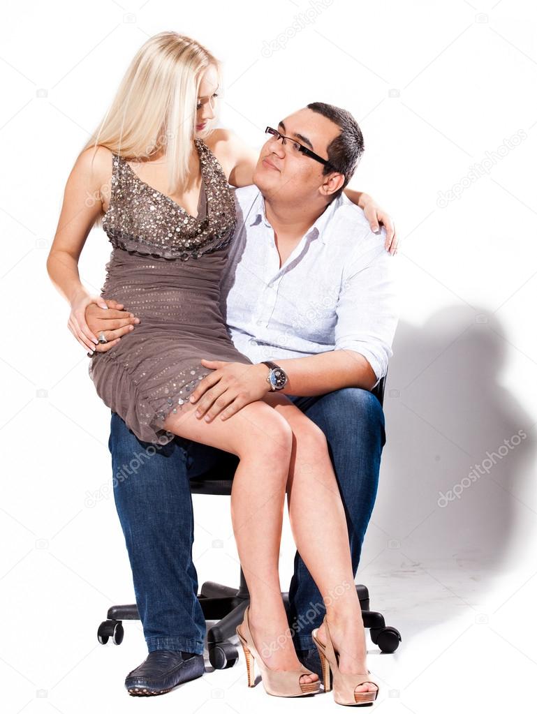 Sexy blond girl sitting on mans knee and hugging