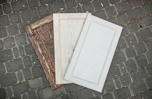 Tre porte in legno adagiate su strada asfaltata — Foto Stock