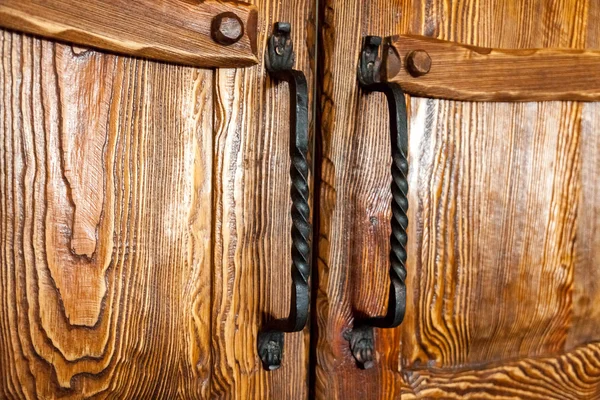 Two forged metal door handles on cupboard — Stock Photo, Image