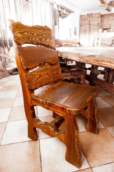 Μεγάλη ξύλινη καρέκλα στέκεται πίσω από το τραπέζι — Φωτογραφία Αρχείου