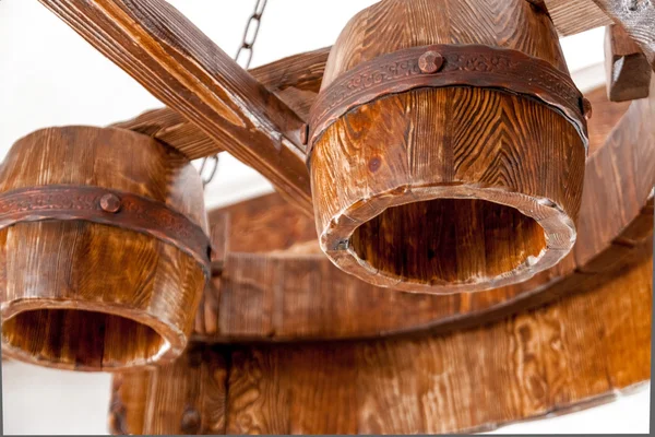 Massive wooden lamp hanging under ceiling — Stock Photo, Image