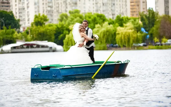 Bride and groom standing and kissing on rowing boat — Stock Photo, Image