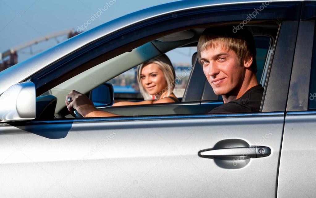 young man and girl sitting in two cars