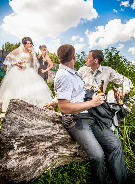 Brudgummen dricker öl med vän medan bruden argumentera — Stockfoto
