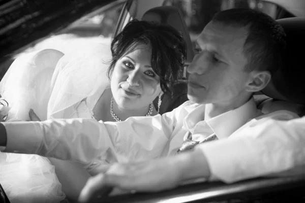 Bride and groom going in car — Stock Photo, Image