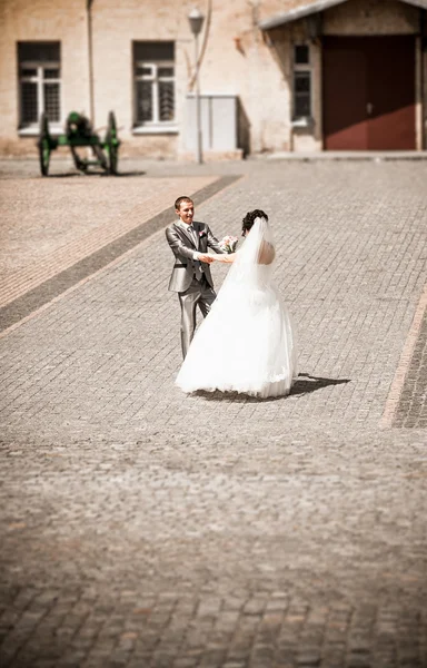 Newly married couple dancing on paving road — Stock Photo, Image