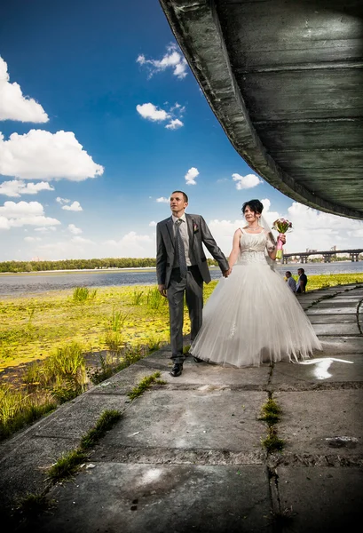 Coppia sposata che cammina su terrapieno tenendosi per mano — Foto Stock