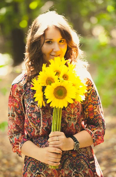 Ragazza bruna che tiene mazzo di girasoli nel parco — Foto Stock