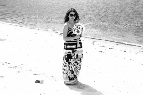 Retrato de menina de vestido em pé na praia perto da água — Fotografia de Stock