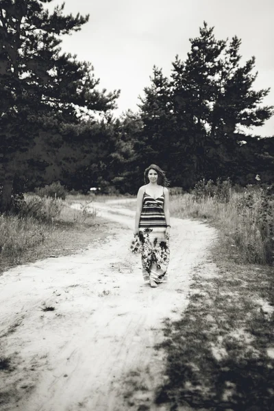 Foto de chica en vestido largo caminando por la carretera en el campo —  Fotos de Stock