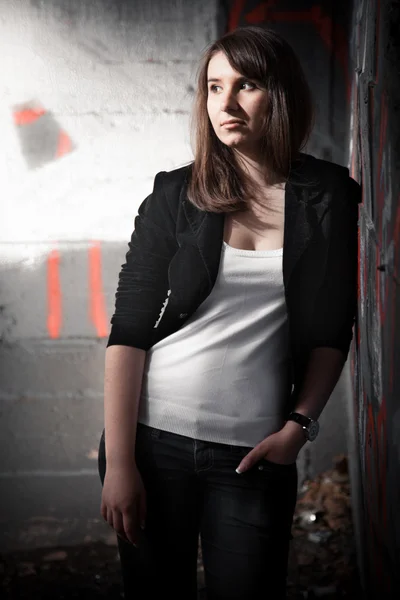 Portrait of brunette girl near graffiti wall — Stock Photo, Image