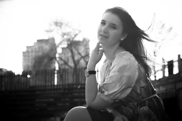 Brunette girl posing against building silhouettes — Stock Photo, Image