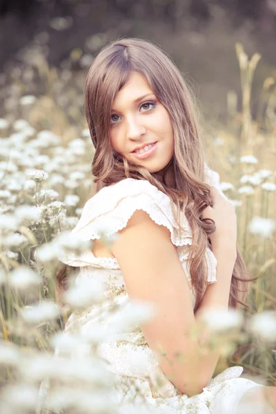 花と草原に横たわってかわいい女 — ストック写真