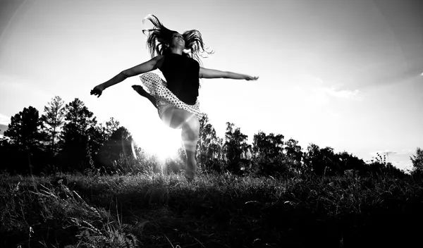 Фото молодой девушки, прыгающей высоко на поле — стоковое фото