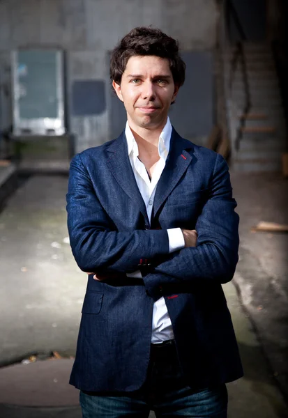 Smiling handsome man in blue jacket standing on street — Stock Photo, Image