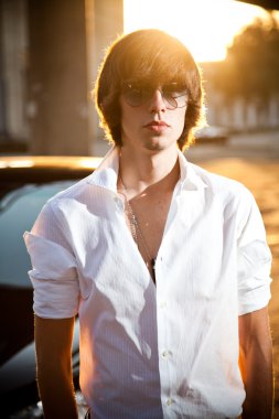 yakışıklı adam beyaz ve arabanın yakınında poz güneş gözlüğü