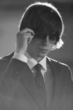 güneş gözlüğü takıyor ve dikkatle bakarak işadamı