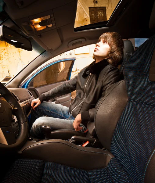 Man sitting on passenger seat and looking in sunroof glass — Stock Photo, Image