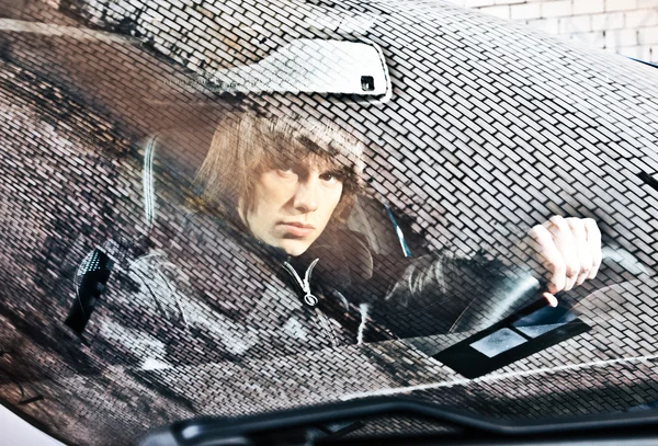 Portrait through windscreen with reflections of man driving car — Stock Photo, Image