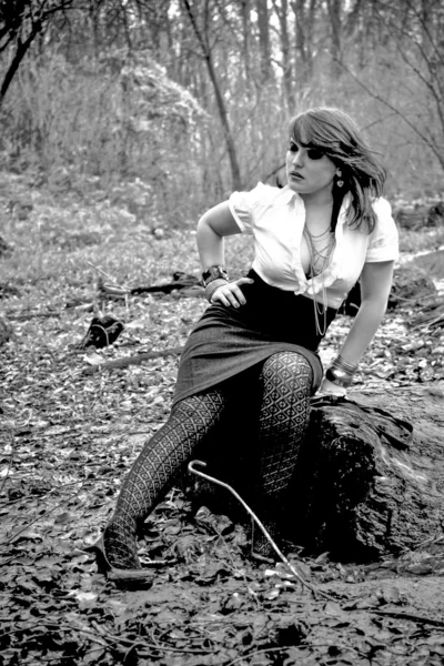 Portrét sexy ženy sedí na log v lese — Stock fotografie