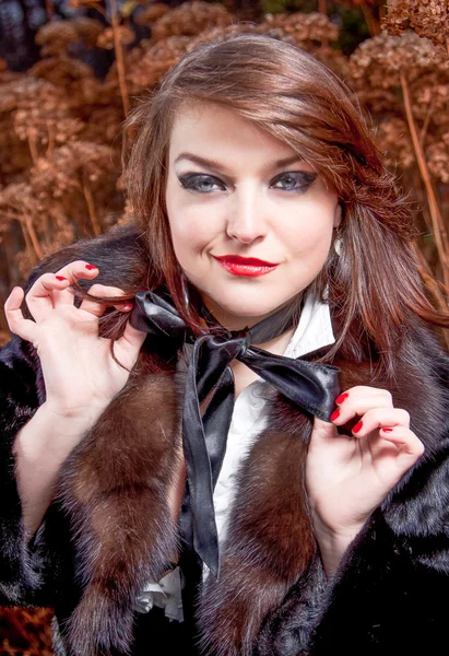 Sexy woman smiling snidely and tying ribbon bow on neck — Stock Photo, Image