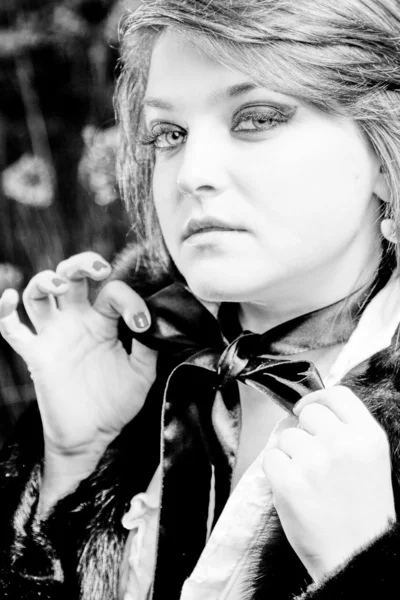 Black and white portrait of chubby woman tying black bow — Stock Photo, Image