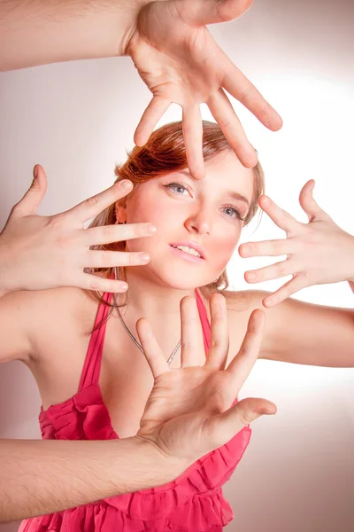 Porträt von vier Händen, die versuchen, brünettes Mädchen zu erreichen — Stockfoto