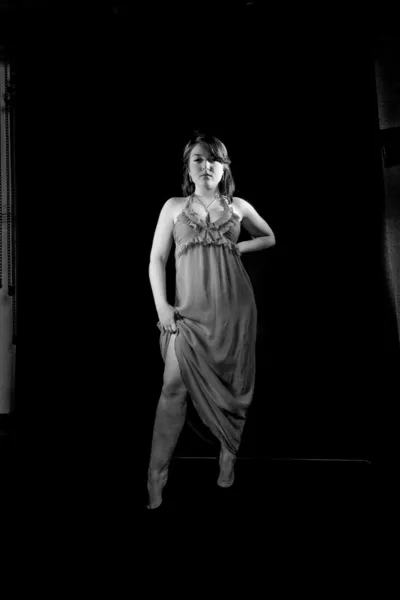 Sexy žena v klasických večerních šatech, které vystupují proti černému pozadí — Stock fotografie