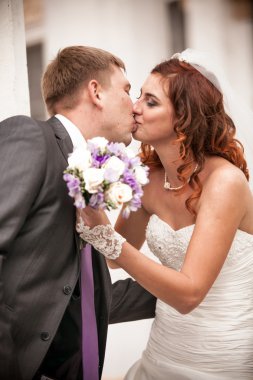 gelin düğün buketi tutarken yakışıklı damat öpüşme