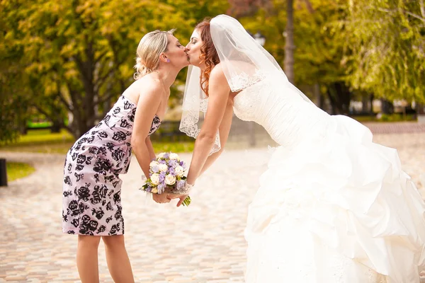 Портрет подружки невесты целующейся с красивой невестой — стоковое фото