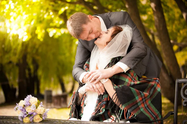 Porträt eines frisch verheirateten Paares, das sich im Herbst auf der Terrasse küsst — Stockfoto