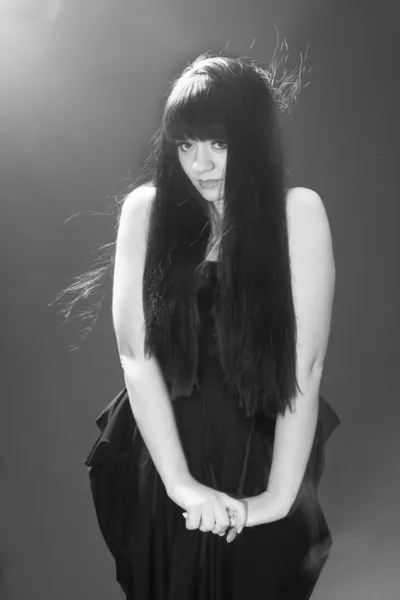 黑色裙与毛发竖立起来的黑发女人的画像 — 图库照片