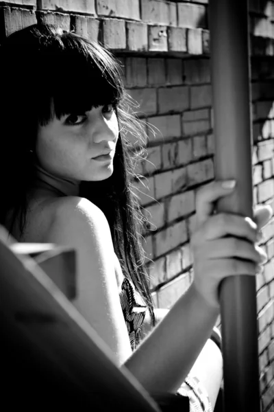 Sexy woman sitting on stairs and turning over shoulder — Stock Photo, Image