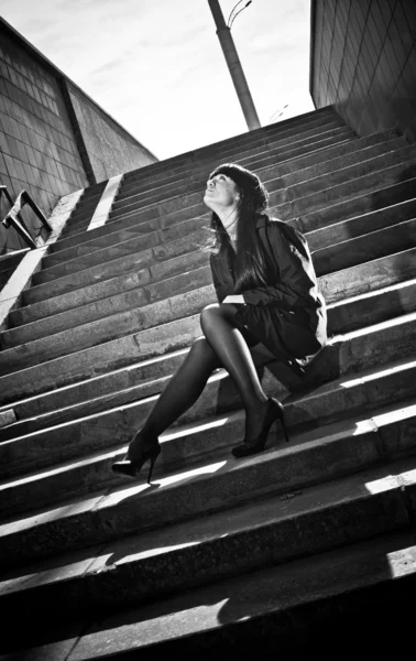 Portrait of sexy woman sitting on stairs on street — Stock Photo, Image