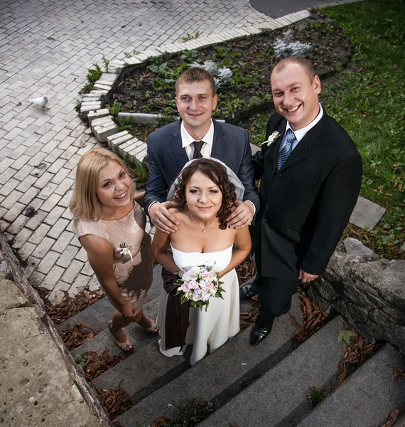 Junges frisch verheiratetes Paar und ihre Freunde schauen auf — Stockfoto