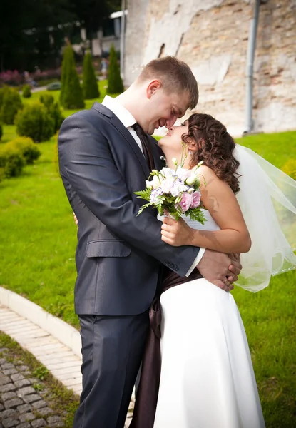 Beau marié câlin heureux mariée au parc — Photo