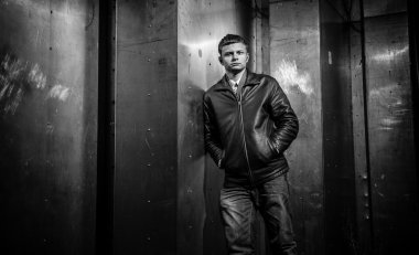 metal duvara yaslanmış deri montlu adam portresi