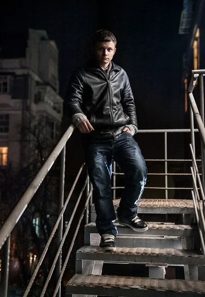 Fashionable man descending from metal staircase at night — Stock Photo, Image