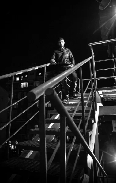 Bonito homem descendo escadas de saída de fogo à noite — Fotografia de Stock