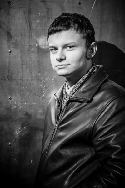 Portrait de jeune homme en manteau de cuir appuyé contre le mur — Photo