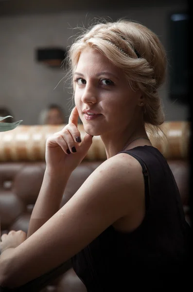 Woman sitting in cafe and turning around to look at camera — Stock Photo, Image