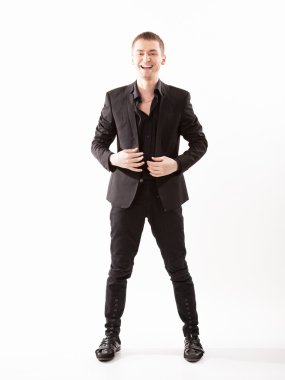 gülümseyen adam siyah takım ayakta beyaz bir arka plana dayanır