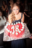 sexy junge Frau hält Geburtstagstorte mit Kerzen